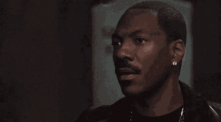 a man with a mustache and earring looks at something