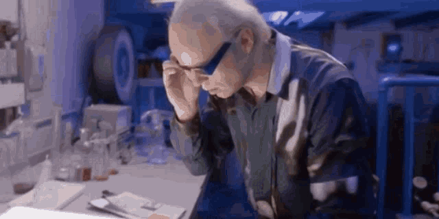 a man wearing glasses is working in a lab .